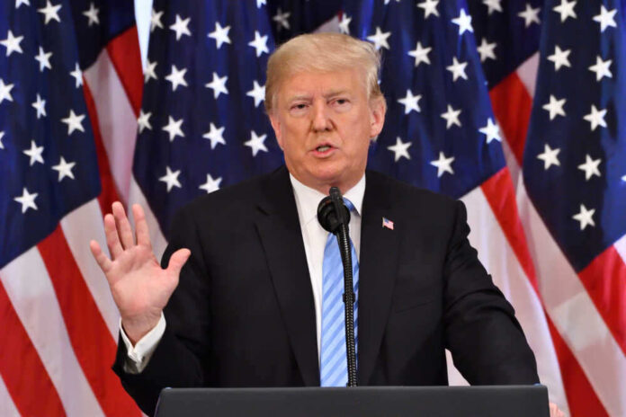 shutterstock_1198949239.jpg featured image A man giving a speech with American flags behind.