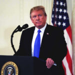 Donald Trump speaking at podium.