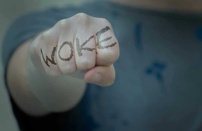 shutterstock_2002018643.jpg featured image Fist with Woke written on fingers.