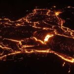 Glowing lava flow at night forming intricate patterns