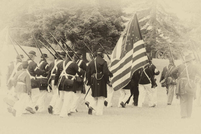 shutterstock_299275949.jpg featured image Civil War reenactors marching with U.S. flag.