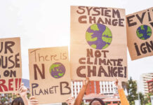 Climate change protest signs being held up outdoors.