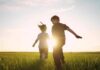Children running in a field at sunset.