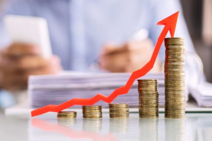 shutterstock_2276983593-1.jpg featured image Stacked coins with upward red arrow graph in foreground.