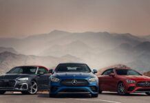 Three luxury cars in front of mountain landscape