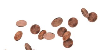 Several scattered pennies on a white background