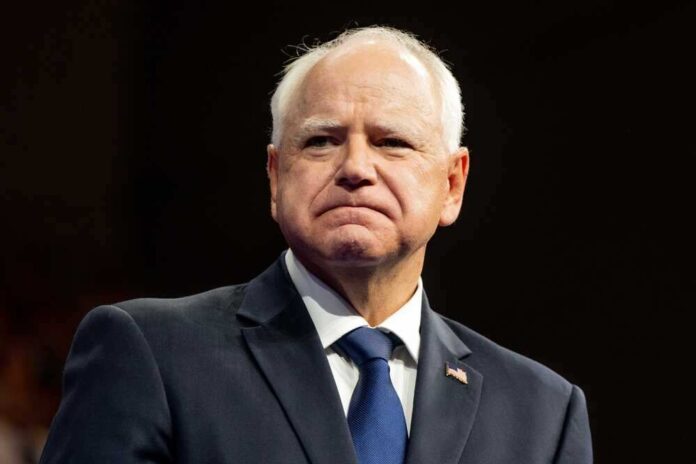 shutterstock_2499464677-1.jpg featured image Tim Walz in suit with American flag pin.