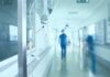 Hospital corridor with IV drip and healthcare worker.