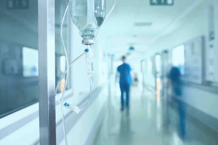 shutterstock_528854752-1.jpg featured image Hospital corridor with IV drip and healthcare worker.