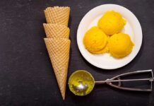 Ice cream scoops, cones, and scoop tool on black background.