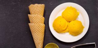 Ice cream scoops, cones, and scoop tool on black background.