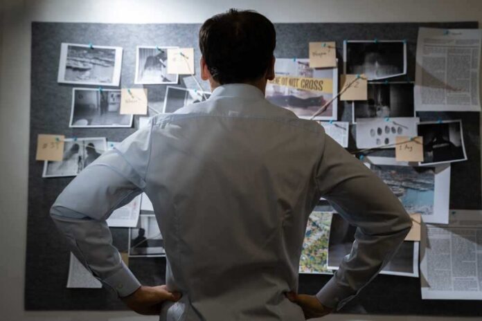 shutterstock_2140725125.jpg featured image Man examining investigation board with photos and notes.