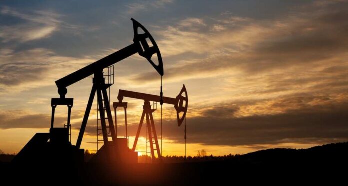 Oil pump jacks silhouetted against sunrise sky