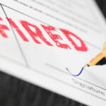 Fountain pen signing document with the word fired