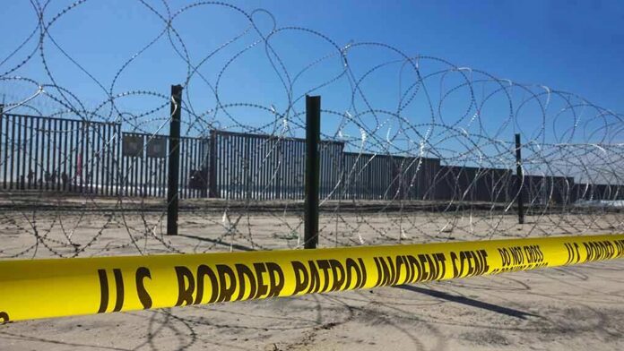 Border patrol tape and barbed wire fence.
