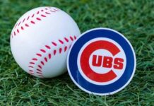 A baseball and a Chicago Cubs logo on green grass