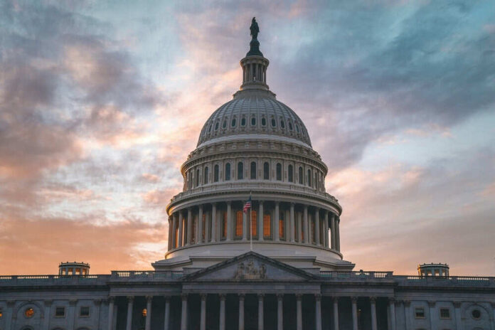 shutterstock_2470608247.jpg Capitol building under cloudy sunset sky