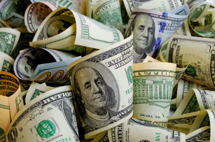 shutterstock_518001346.jpg Rolled U.S. dollar bills in various denominations.