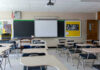 Empty classroom with desks projector and chalkboard