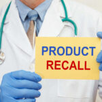 Doctor holding a product recall sign in gloves
