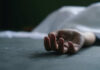Dead persons hand lying on a gray surface