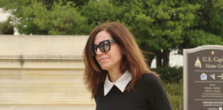 Congresswoman Nancy Mace in sunglasses walking near visitor center sign