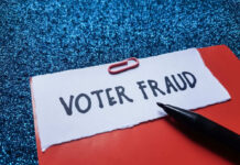 Paperclip holding paper labeled voter fraud marker