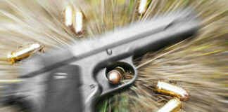Pistol and bullets on grass with motion blur effect