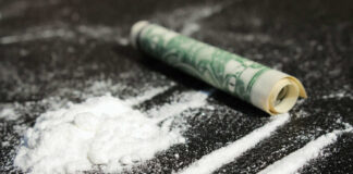 Cocaine lines with rolled banknote on surface