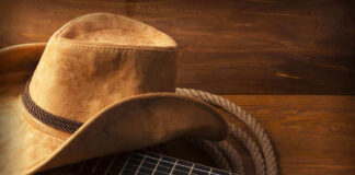 Cowboy hat on guitar next to coiled rope