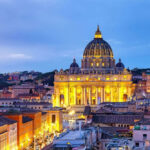 Illuminated St Peters Basilica at dusk Rome skyline