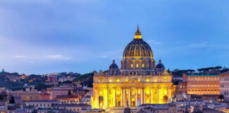Illuminated St Peters Basilica at dusk Rome skyline