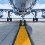 Airplane on runway with visible landing gear engines
