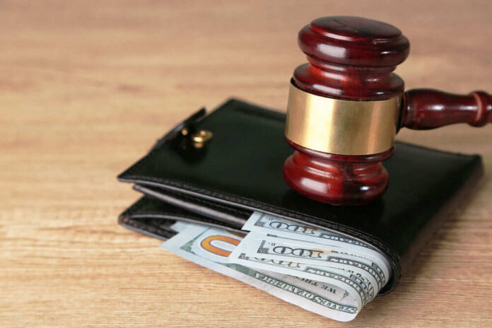 Gavel on wallet with visible dollar bills