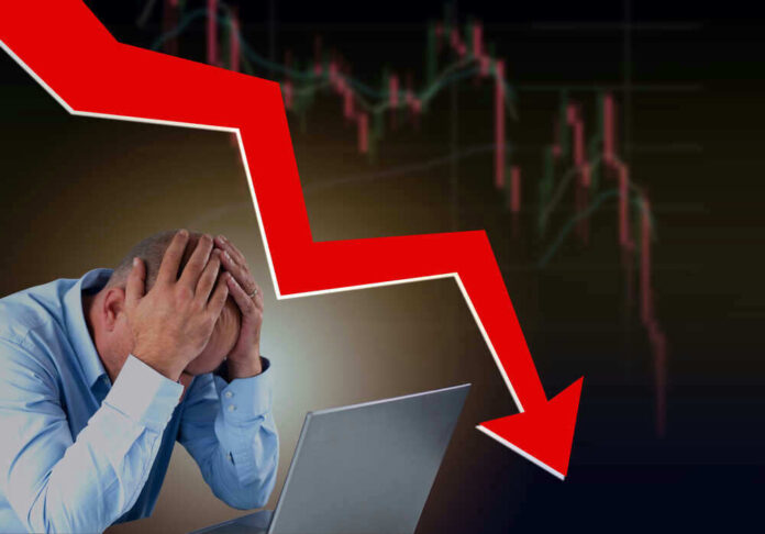 Man stressed over falling stock market graph.