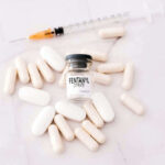 Fentanyl citrate vial surrounded by various pills and syringe.