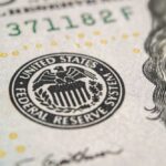 Close-up of a United States dollar bill featuring the Federal Reserve emblem
