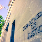 Trump DOJ Disrupts Terrorist ATM Scheme Department of Justice building with American flag.
