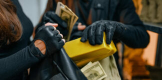 Individuals in black clothing stealing money and items