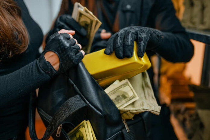 Individuals in black clothing stealing money and items