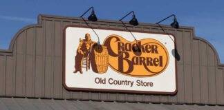 Sign for Cracker Barrel Old Country Store featuring a man sitting on a barrel