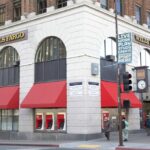 Exterior view of a Wells Fargo bank with red awnings and a street sign