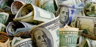 Rolled U.S. dollar bills in various denominations.