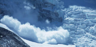 An avalanche cascading down a glacier in a mountainous region