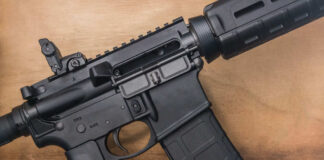 Black rifle on wooden surface close up