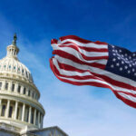 U.S. Capitol building with American flag waving.