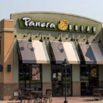 Exterior view of a Panera Bread restaurant with outdoor seating