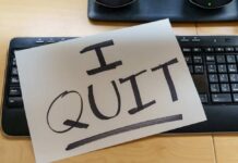 A resignation letter reading 'I QUIT' placed on a keyboard