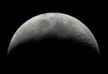 Half moon in a black sky with visible craters.