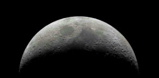 Half moon in a black sky with visible craters.
